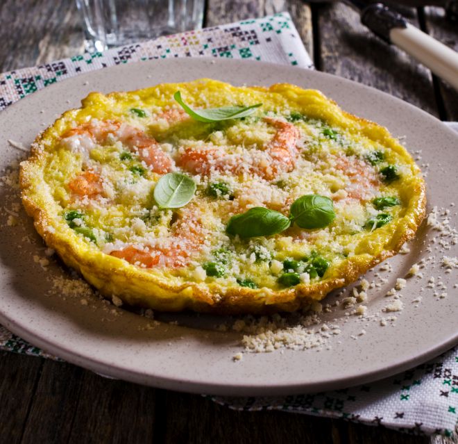 Omelet with shrimp and peas in a rustic style. Selective focus.