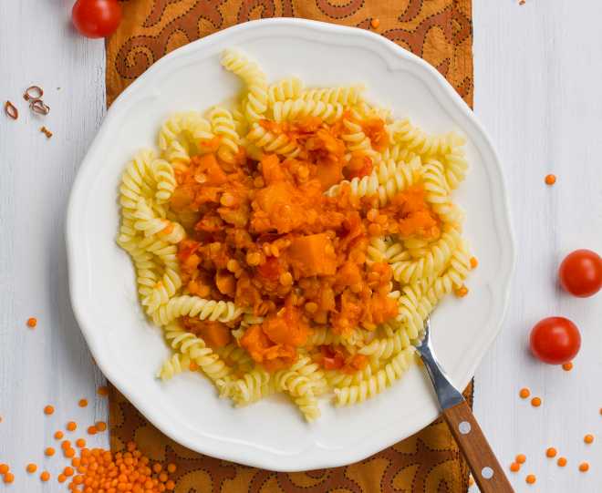 piatto di pasta con ragù vegetale lenticchie rosse e zucca