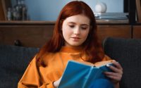 ragazza adolescente immersa nella lettura di un libro