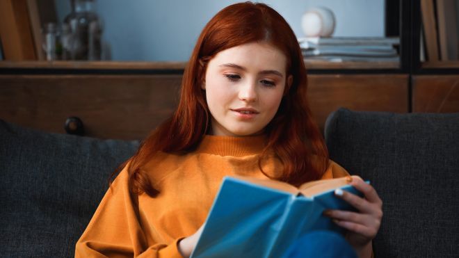 ragazza adolescente immersa nella lettura di un libro