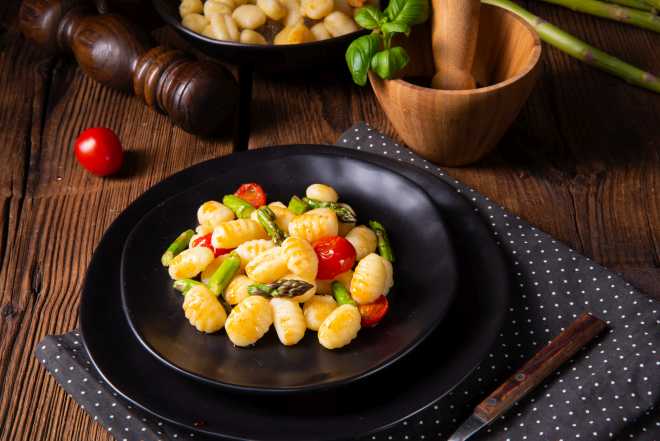 primo piatto con gnocchi, punte di asparagi e pomodorini freschi